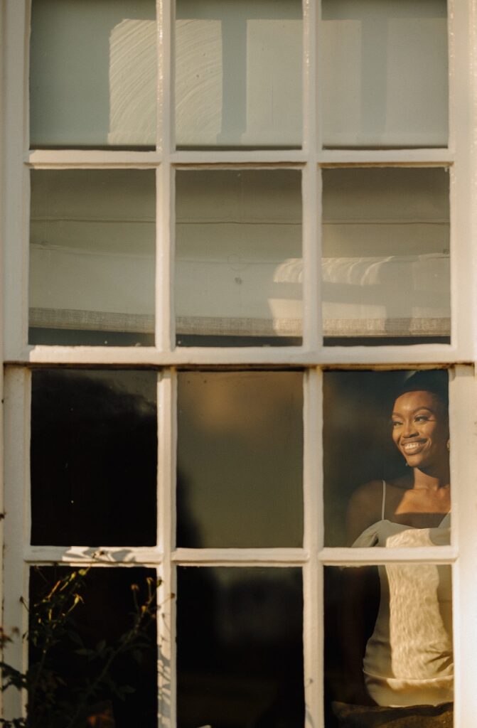 Woman Looking Out Of The Window Smiling